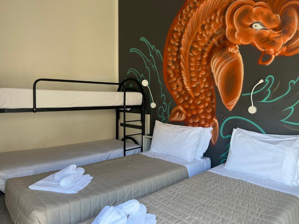 Ce lit se trouve dans un dortoir doté de 2 lits superposés et d'une peinture murale. dans l'établissement X Hotel, à Punta Marina