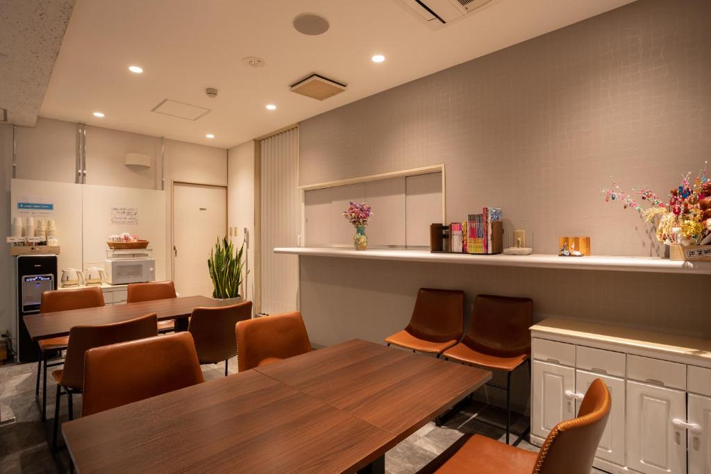 un restaurant avec des tables, des chaises et un comptoir dans l'établissement Sakura Ryokan Asakusa Iriya, à Tokyo