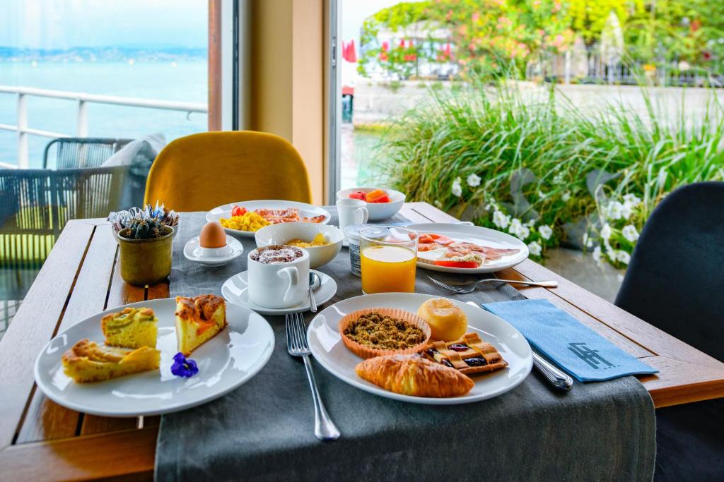 une table avec des assiettes de petit-déjeuner dessus dans l'établissement Hotel Flaminia, à Sirmione