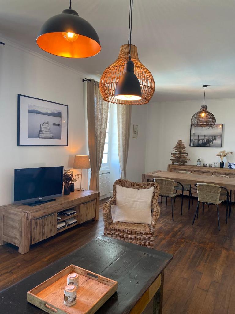 un salon avec une télévision et une table dans l'établissement Domaine de Cazal - Gîte 2 pers avec piscine au cœur de 26 hectares de nature préservée, à Saint-Cyprien