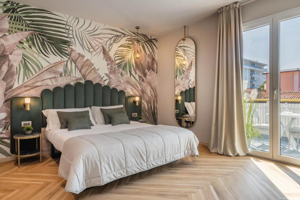 une chambre avec un grand lit orné d'une fresque tropicale dans l'établissement Salus Smart & Chic Hotel, à Lido di Jesolo 48 autres photos