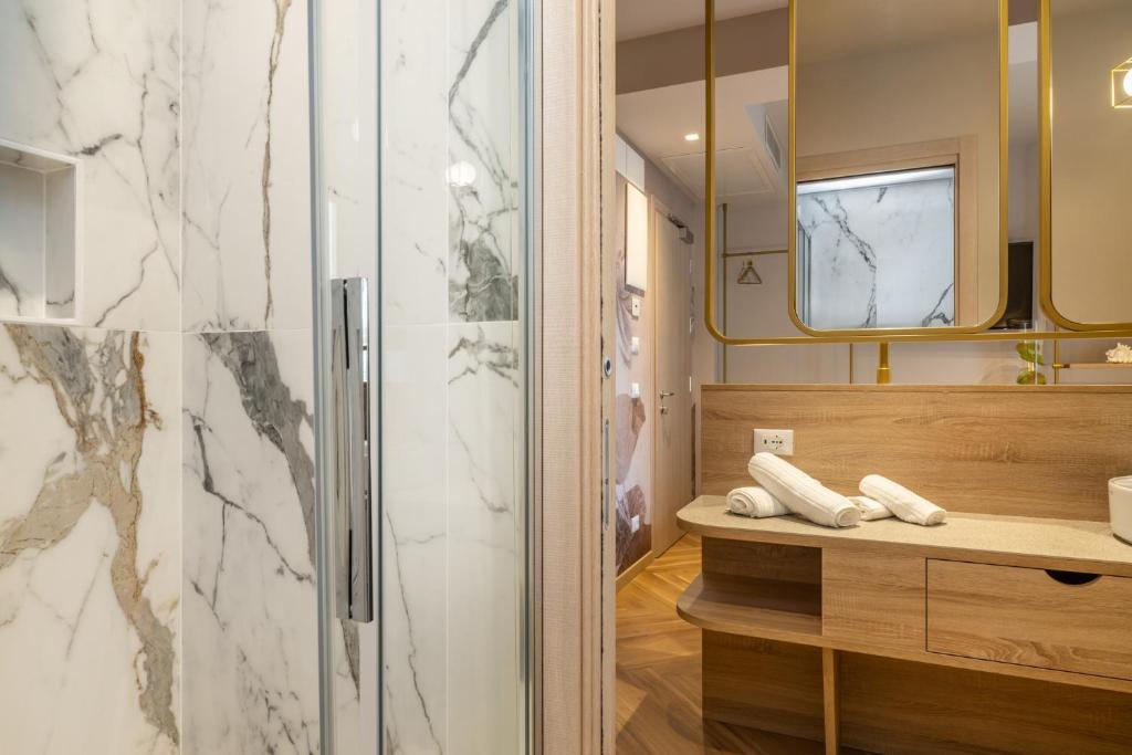 une salle de bains avec douche et télévision dans l'établissement Salus Smart & Chic Hotel, à Lido di Jesolo