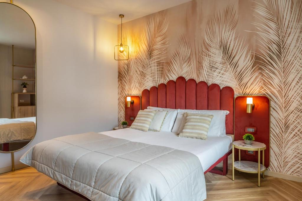 une chambre avec un grand lit avec une tête de lit rouge dans l'établissement Salus Smart & Chic Hotel, à Lido di Jesolo