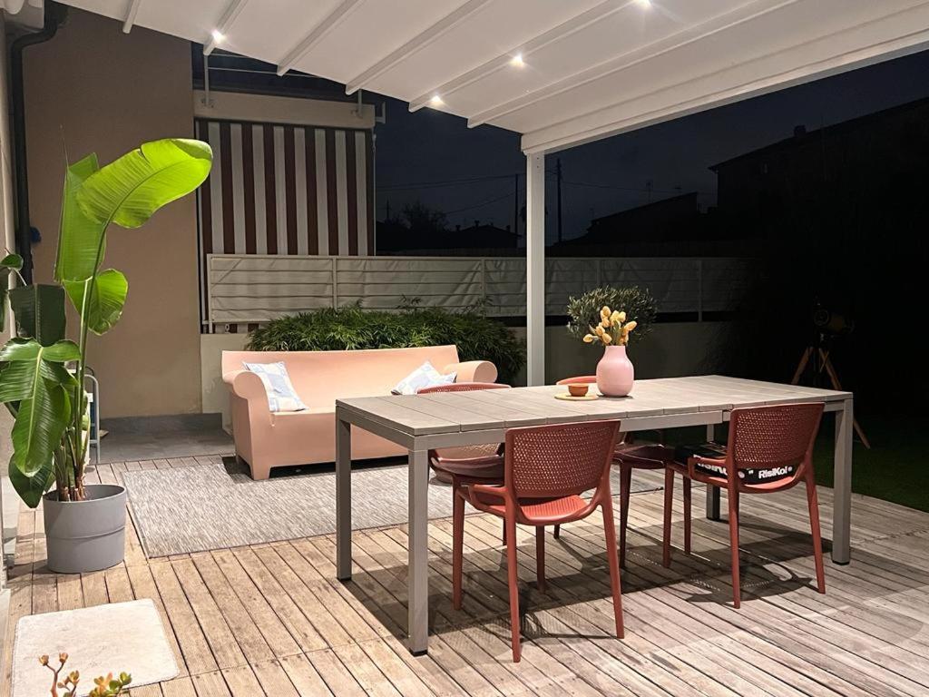 une table et des chaises assises sur une terrasse dans l'établissement Villa Theoma, à Castelnuovo Magra
