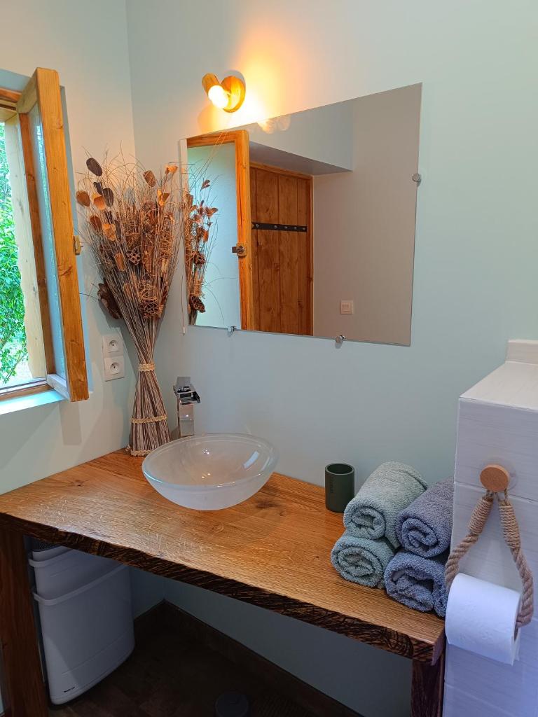 une salle de bain avec un lavabo, un miroir et des serviettes dans l'établissement Tente mongole " ô Rêves Atypiques", à Boucé