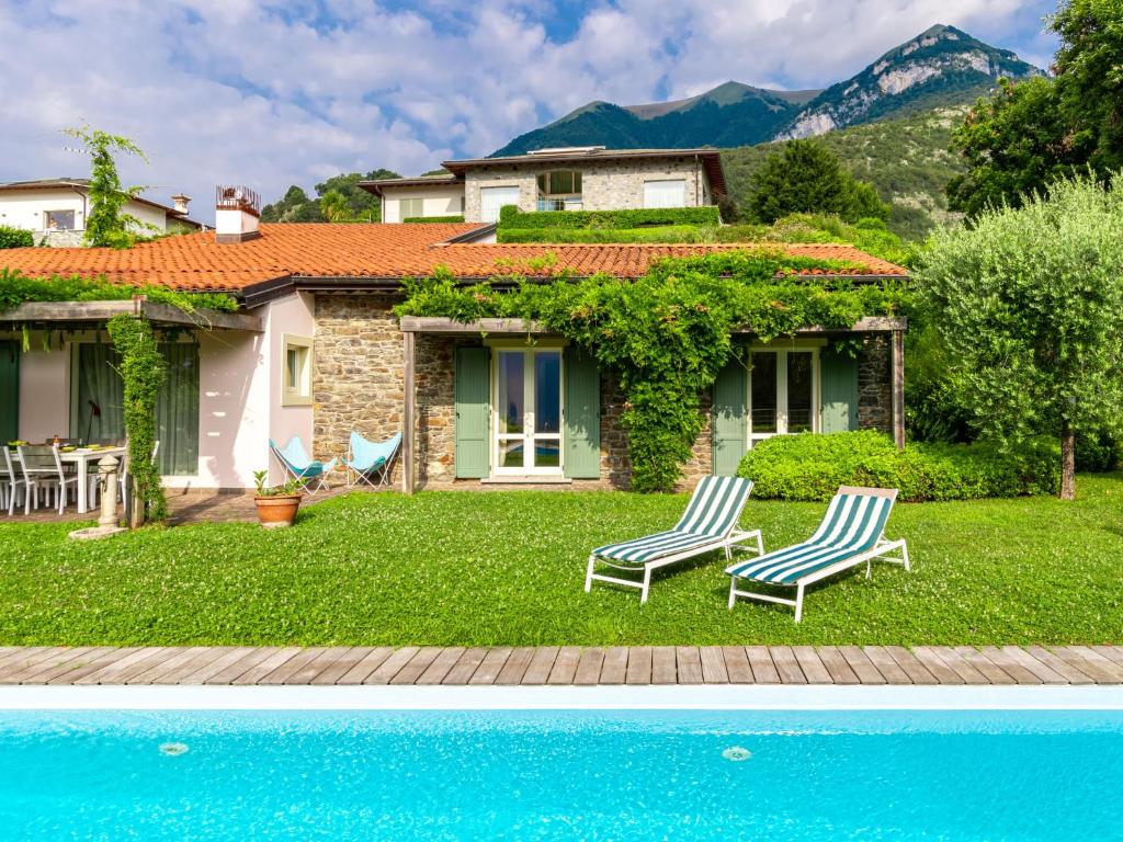 une maison avec deux chaises et une piscine dans l'établissement Villa Villa Ulivo by Interhome, à Griante Cadenabbia