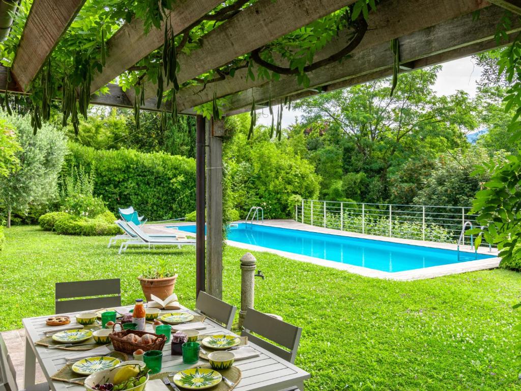 - une table avec de la nourriture dans une cour avec une piscine dans l'établissement Villa Villa Ulivo by Interhome, à Griante Cadenabbia