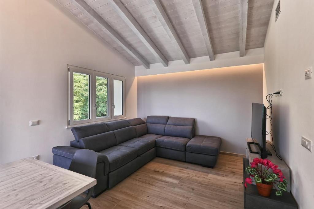 un salon avec un canapé et une télévision dans l'établissement Villa Pineta - Theater Home, à Tignale