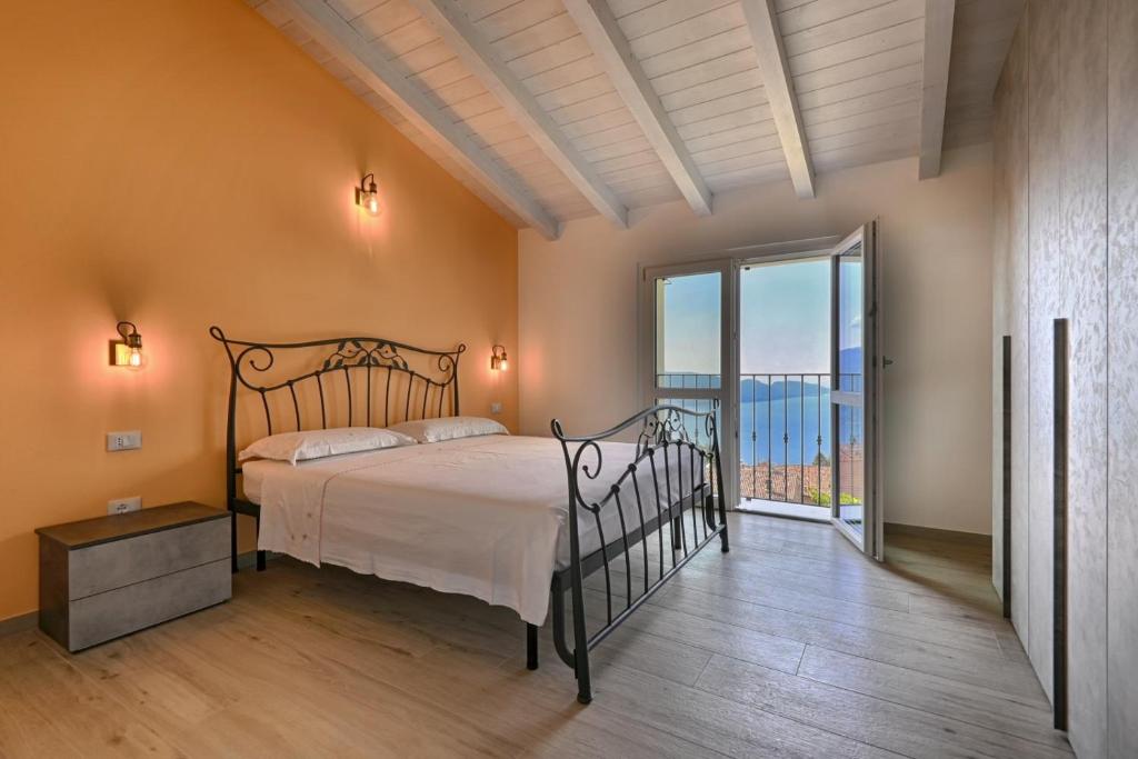 une chambre avec un lit et une grande fenêtre dans l'établissement Villa Pineta - Theater Home, à Tignale