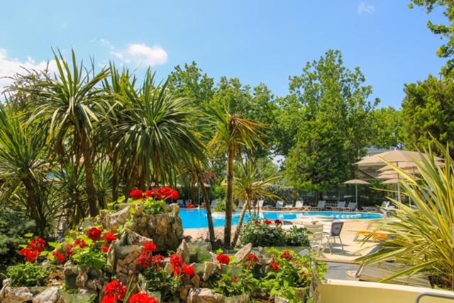 un jardin fleuri et une piscine dans l'établissement RESIDENZA ANNESSA Hotel Duca di Kent, à Cesenatico