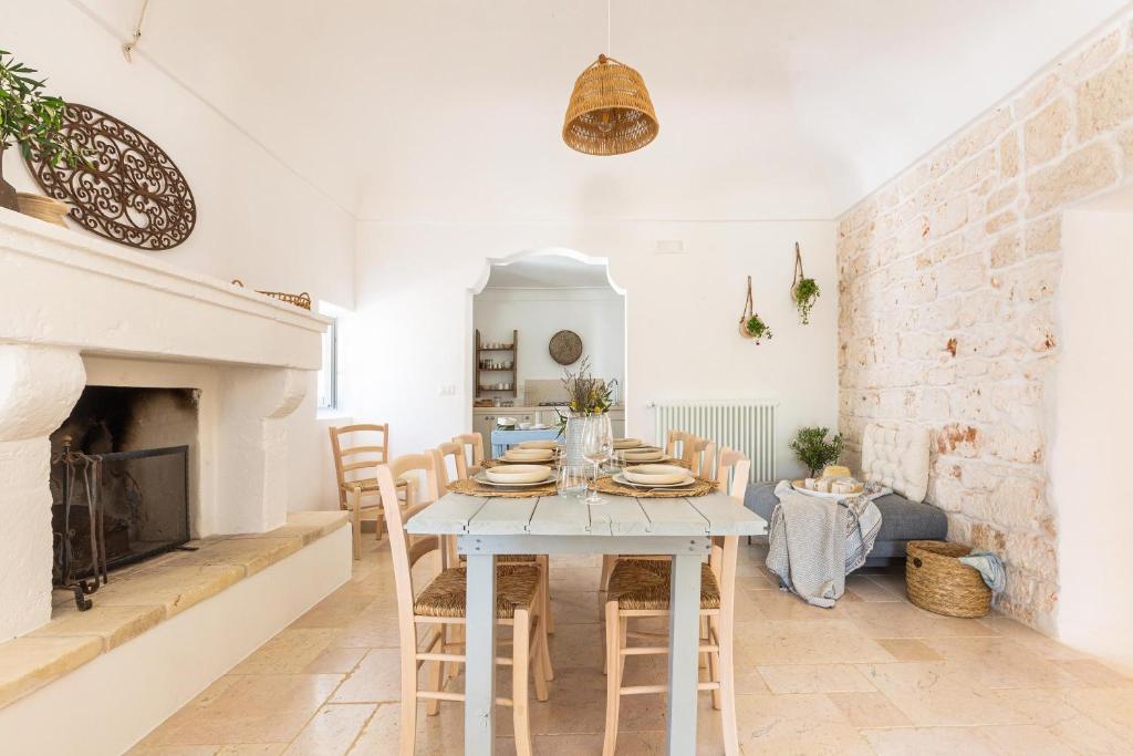 une salle à manger avec une table et une cheminée dans l'établissement Borgo Treffe by Perle di Puglia, à Carovigno