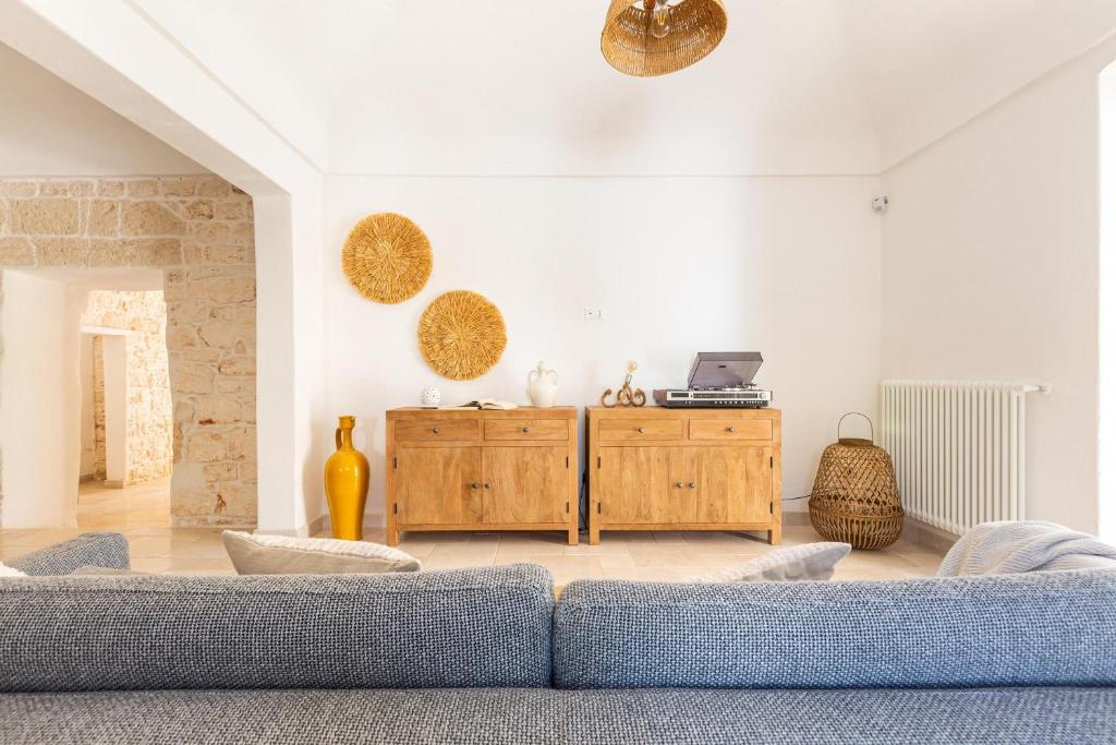 - un salon avec un canapé et une armoire en bois dans l'établissement Borgo Treffe by Perle di Puglia, à Carovigno