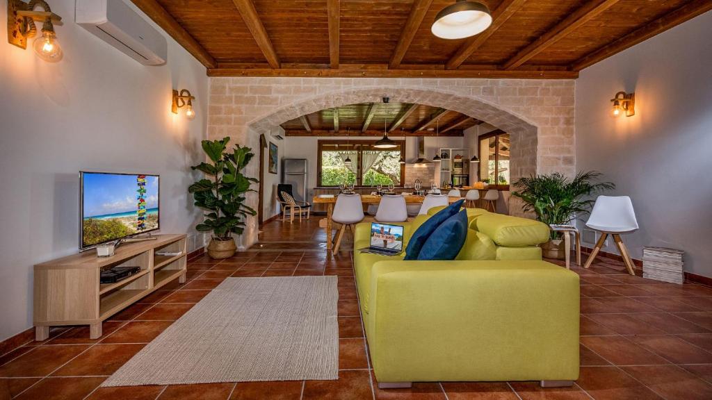 - un salon avec un canapé jaune et une télévision dans l'établissement VILLA CUTRERA 8, Emma Villas, à Chiaramonte Gulfi