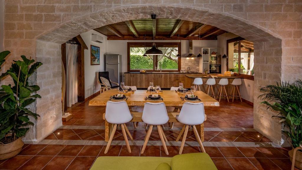 une cuisine et une salle à manger avec une table et des chaises dans l'établissement VILLA CUTRERA 8, Emma Villas, à Chiaramonte Gulfi