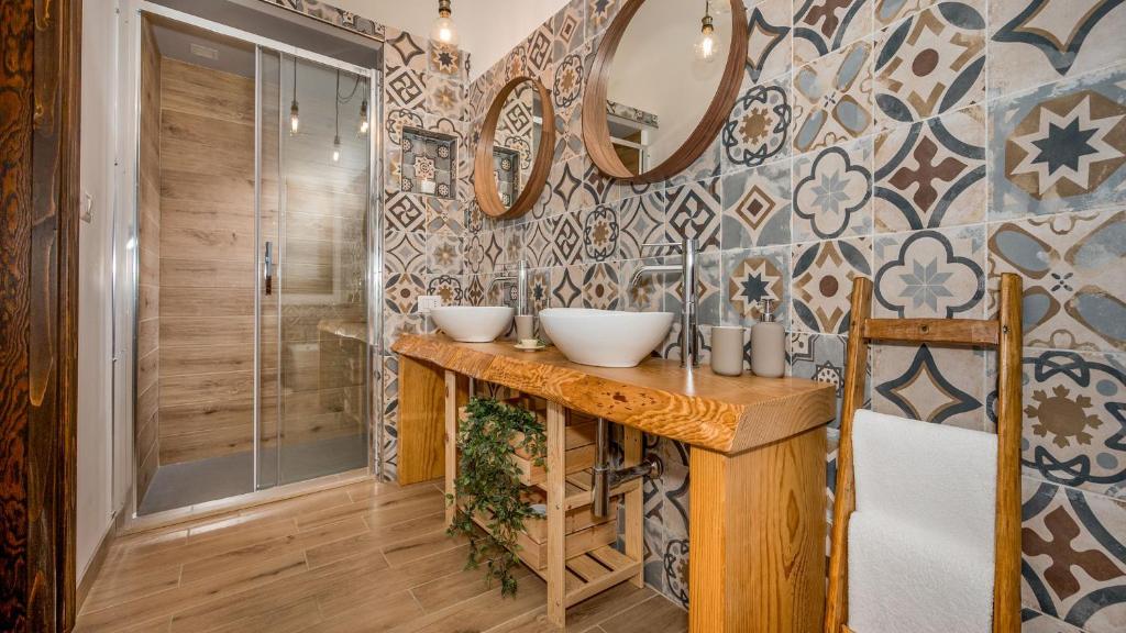 une salle de bain avec deux lavabos et une douche dans l'établissement VILLA CUTRERA 8, Emma Villas, à Chiaramonte Gulfi