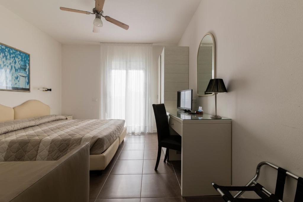 une chambre avec un lit et un bureau avec une télévision dans l'établissement Hotel Miami, à Lido di Jesolo