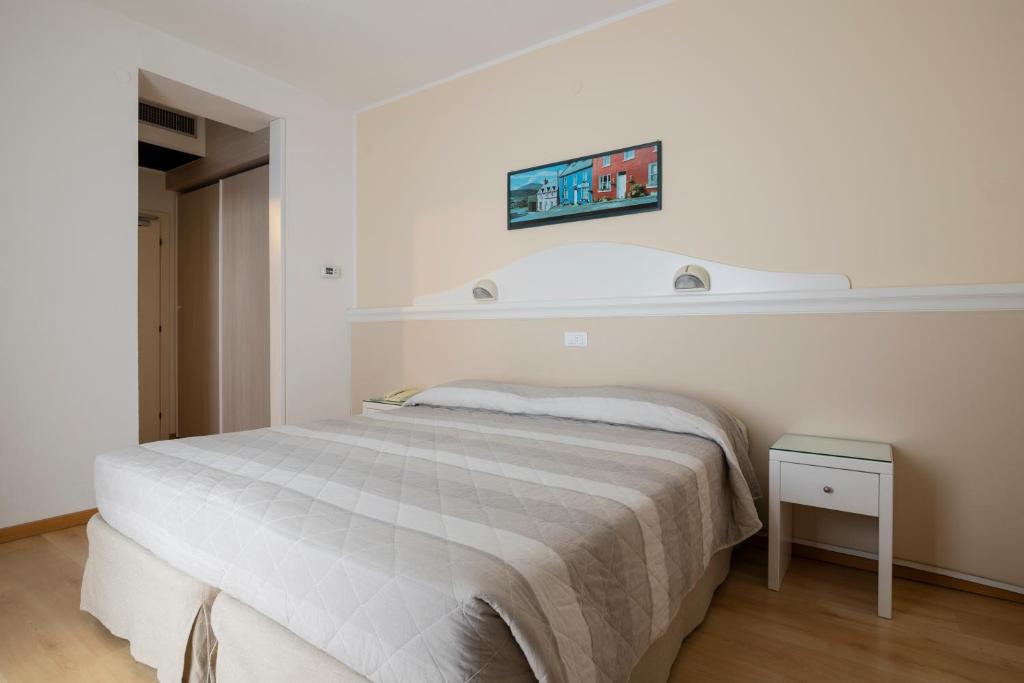 une chambre blanche avec un lit et une télévision au mur dans l'établissement Hotel Miami, à Lido di Jesolo 17 autres photos