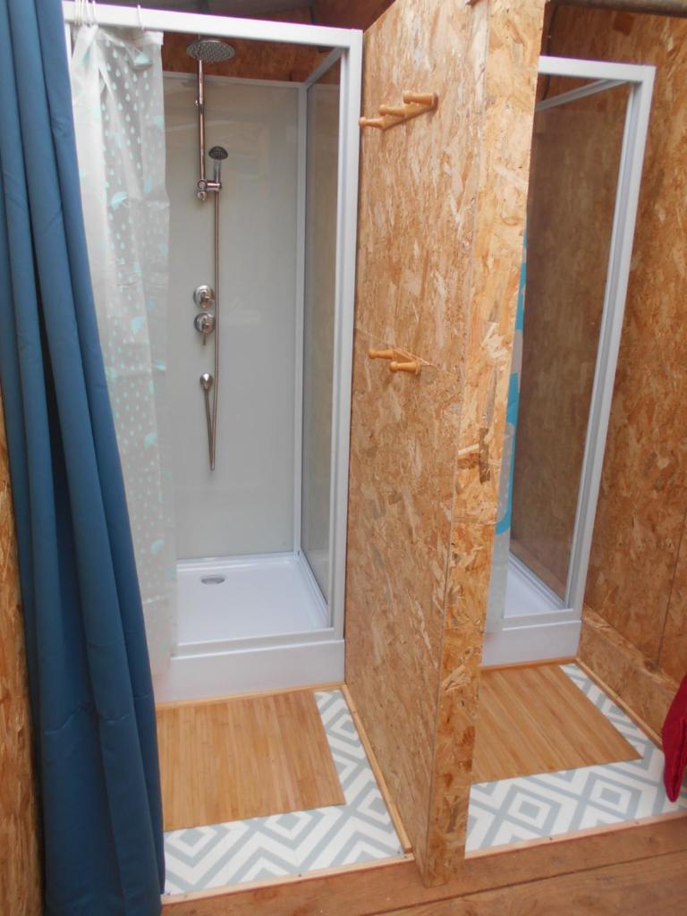 La salle de bains est pourvue d'une douche et de 2 fenêtres. dans l'établissement Sous les Toiles de PauTiLou, à Molles