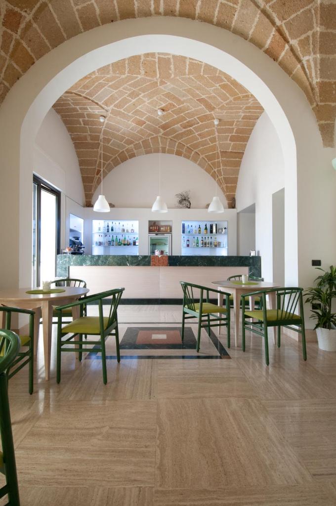 une salle à manger avec des tables et des chaises vertes dans l'établissement Grand Hotel Mediterraneo, à Santa Cesarea Terme