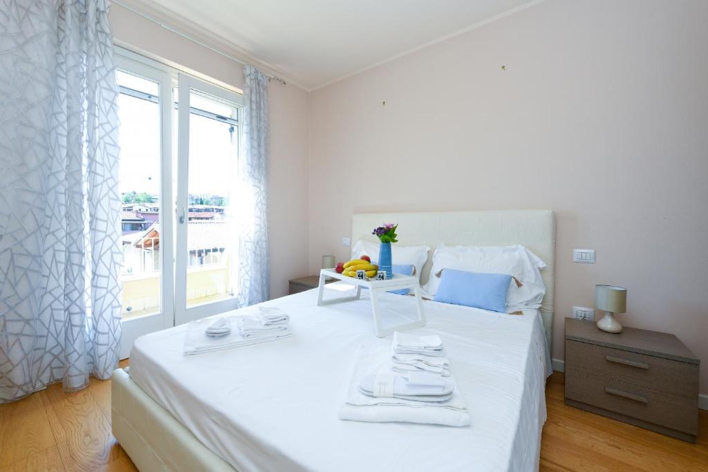 une chambre avec un grand lit blanc avec une fenêtre dans l'établissement Villa Iris, à Manerba del Garda