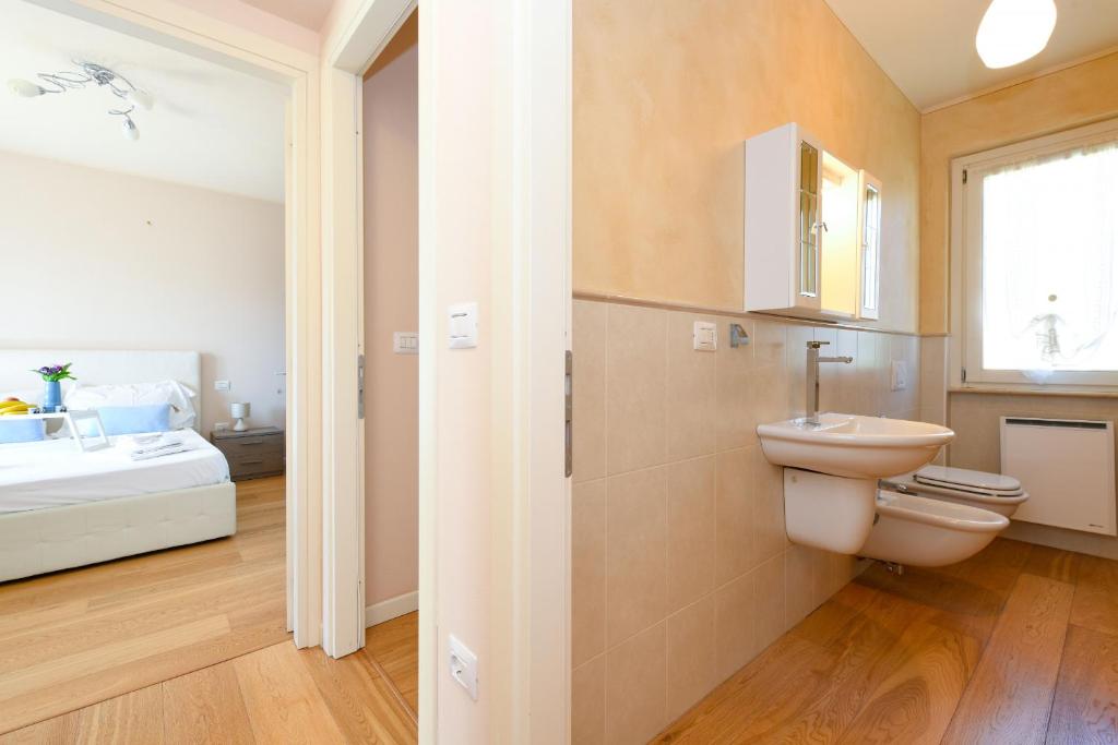 une salle de bain avec toilettes et lavabo et un lit dans l'établissement Villa Iris, à Manerba del Garda