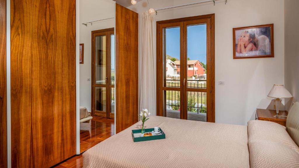 Cette chambre comprend un lit avec une table et une fenêtre. dans l'établissement Villa delle Sirene 6, Emma Villas, à Valderice