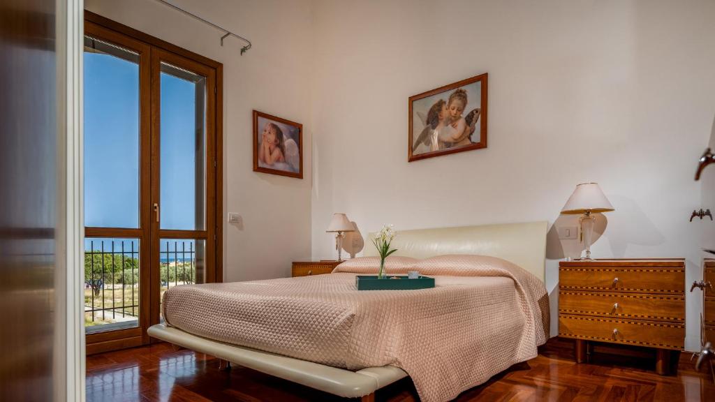 une chambre avec un lit avec une table et une fenêtre dans l'établissement Villa delle Sirene 6, Emma Villas, à Valderice 22 autres photos