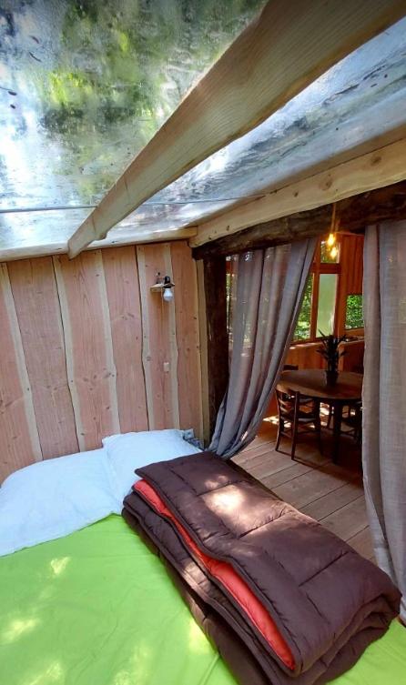 Ce lit se trouve dans une chambre située dans une maison. dans l'établissement Cabane Salamandre, à Saint-Éloy-les-Tuileries