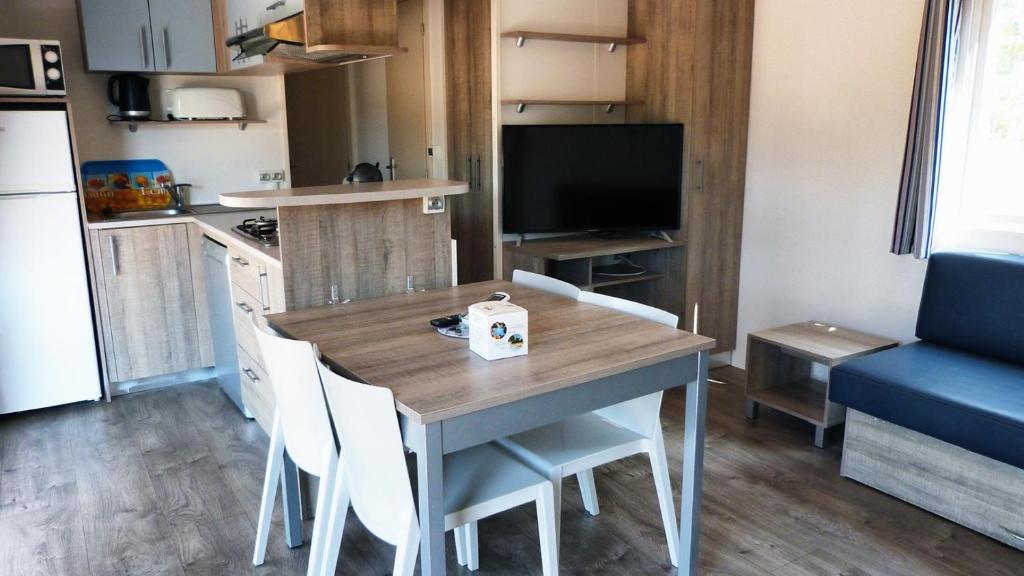 une petite cuisine avec une table et des chaises dans une pièce dans l'établissement MOBILOCAMP, au Muy