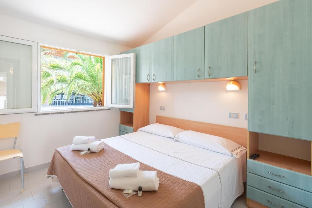 une chambre avec un grand lit avec des armoires bleues dans l'établissement Golfo di Maremma Village, à Albinia