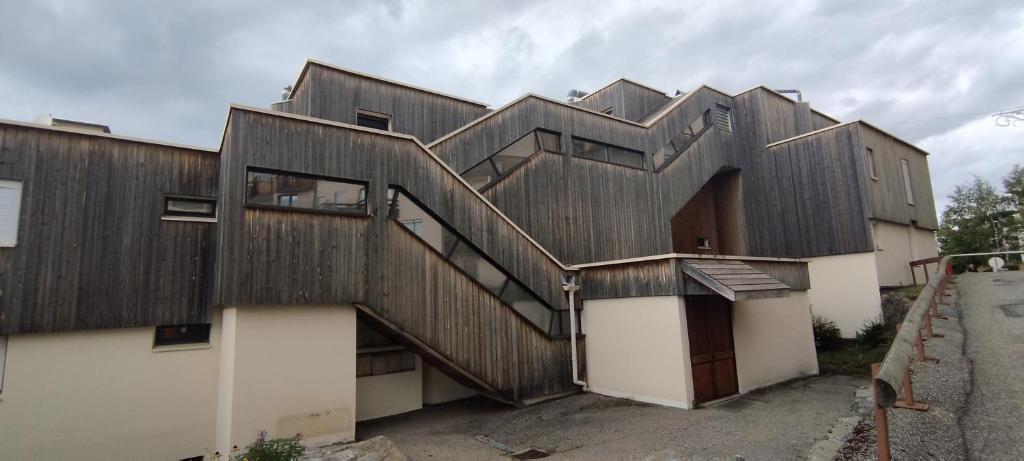 une maison en bois avec un escalier sur son côté dans l'établissement Prapoutel, à Prapoutel