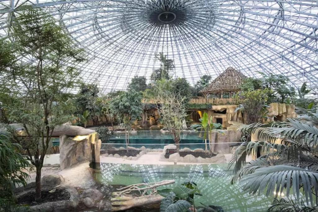 un grand dôme en verre avec une piscine dans un jardin dans l'établissement Mobil-Home 4 étoiles avec piscine proche de Blois, à Onzain