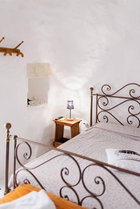 une chambre avec un lit avec une lampe sur une table dans l'établissement 19th century Trullo Raeda in the middle of nature, à Nardò 33 autres photos
