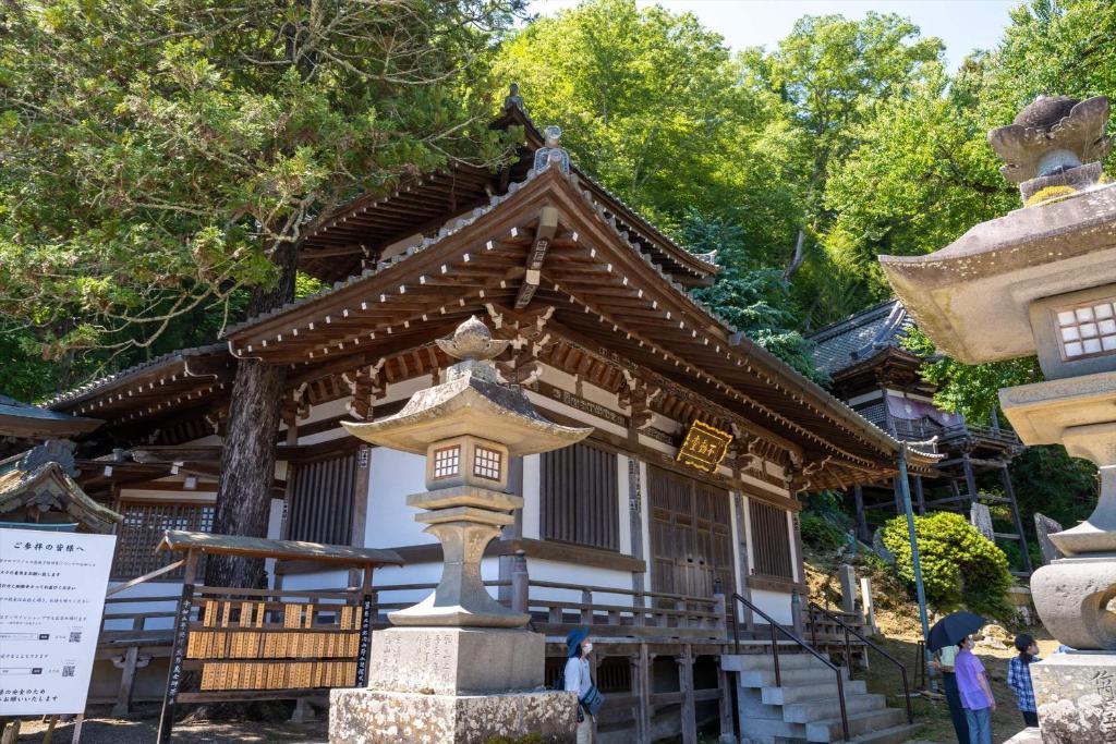 un bâtiment avec une pagode devant lui dans l'établissement Bessho Onsen Midoriya, à Ueda