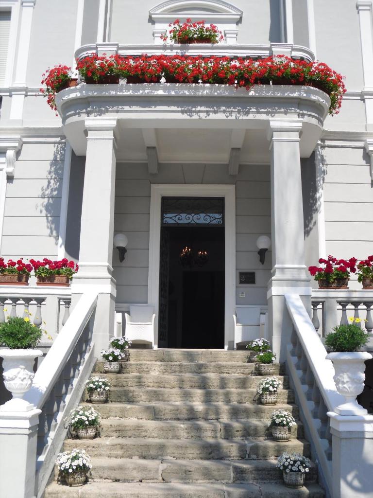 un escalier menant à un bâtiment avec des fleurs rouges dans l'établissement Esedra Hotel, à Rimini
