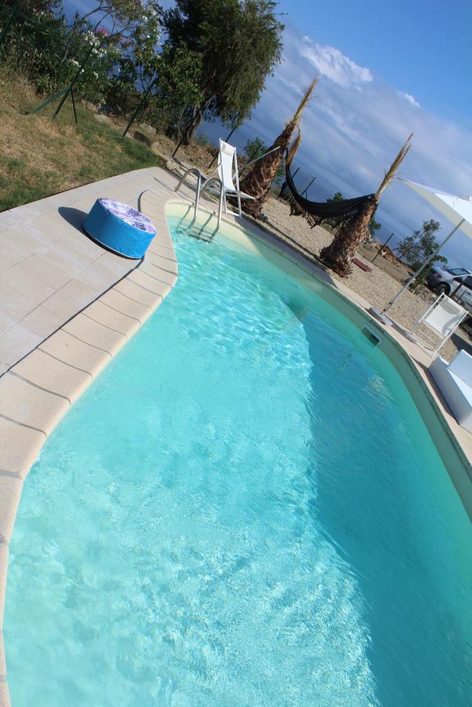 une grande piscine bleue avec un banc et des chaises dans l'établissement Villa CliCla - Pool, sea,hommock swing and laziness, à Imperia 47 autres photos