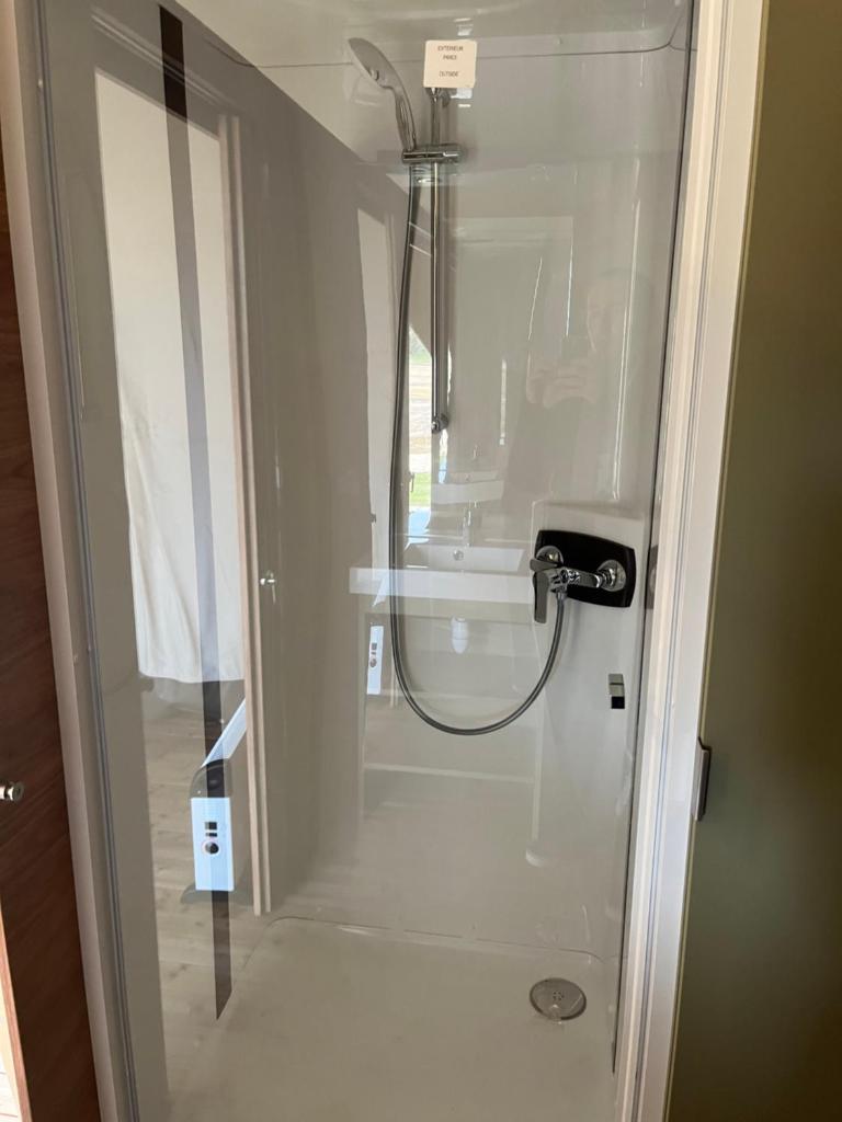 une douche dans une salle de bain avec une porte vitrée dans l'établissement UCPA Eco Lodge, à Séné