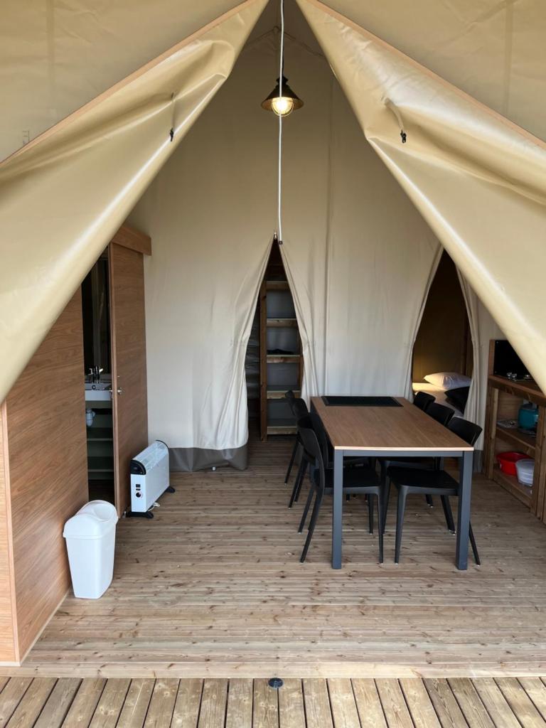 une tente avec une table et des chaises à l'intérieur dans l'établissement UCPA Eco Lodge, à Séné