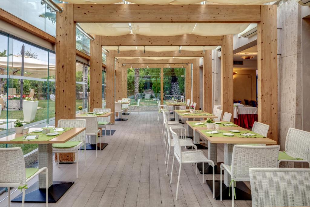 une salle à manger avec tables, chaises et fenêtres dans l'établissement Hotel Sportsman, à Bardolino