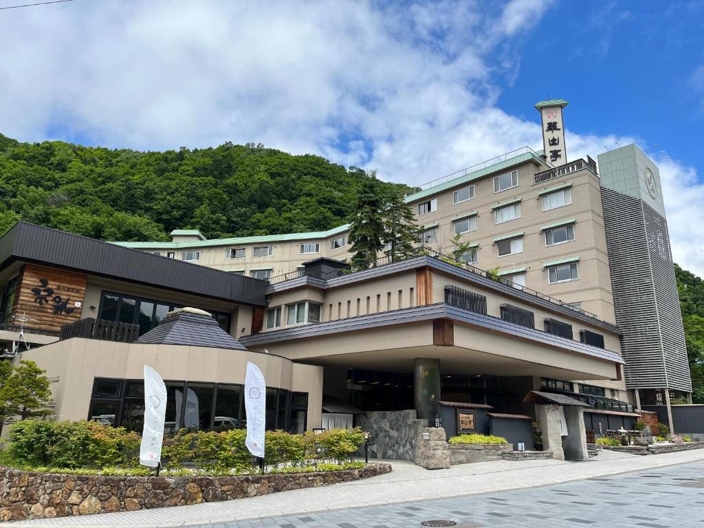 un bâtiment d'hôtel avec une montagne en arrière-plan dans l'établissement Jozankei Daiichi Hotel Suizantei, à Jozankei
