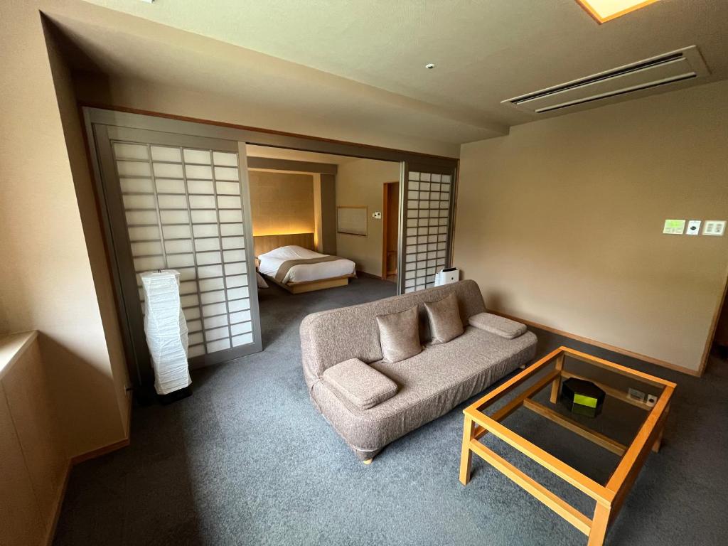 un salon avec un canapé et un lit dans l'établissement Jozankei Daiichi Hotel Suizantei, à Jozankei 151 autres photos