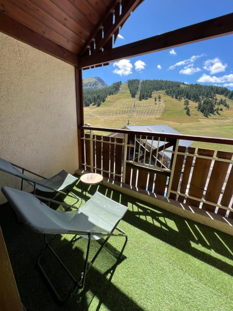 un balcon avec des chaises et une vue sur les montagnes dans l'établissement Les Tanières de Montgenèvre - Studio Dama - neuf 4p avec terrasse vue imprenable, à Montgenèvre