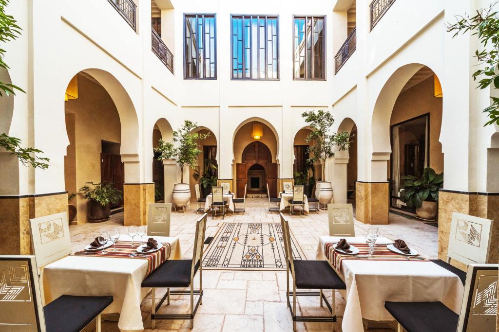 un restaurant avec des tables et des chaises dans un bâtiment dans l'établissement Villa Makassar, à Marrakech