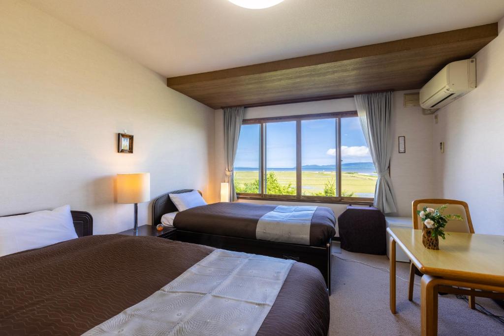 une chambre d'hôtel avec deux lits et une fenêtre dans l'établissement Kagariya, à Abashiri