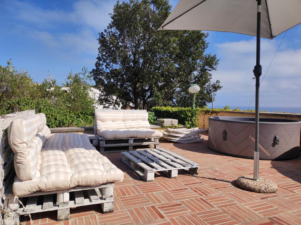 - une terrasse avec 2 chaises longues et un parasol dans l'établissement Villa Quadrifoglio, à Arenzano