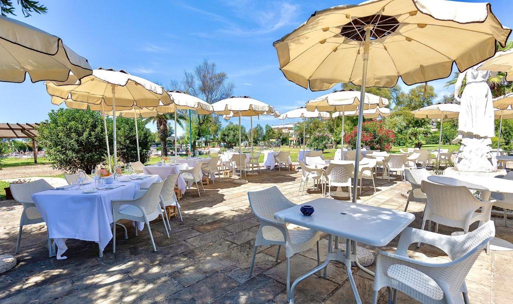 un groupe de tables et de chaises avec parasols dans l'établissement Riva di Palo Beach Hotel, à Ladispoli