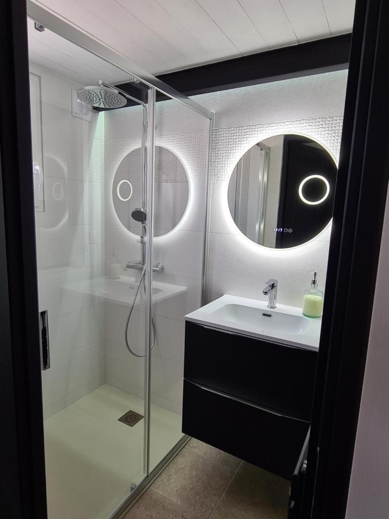 une salle de bain avec une douche, un lavabo et un miroir dans l'établissement Gîte spa la parenthèse,privatif,sauve,gard,Occitanie, à Sauve