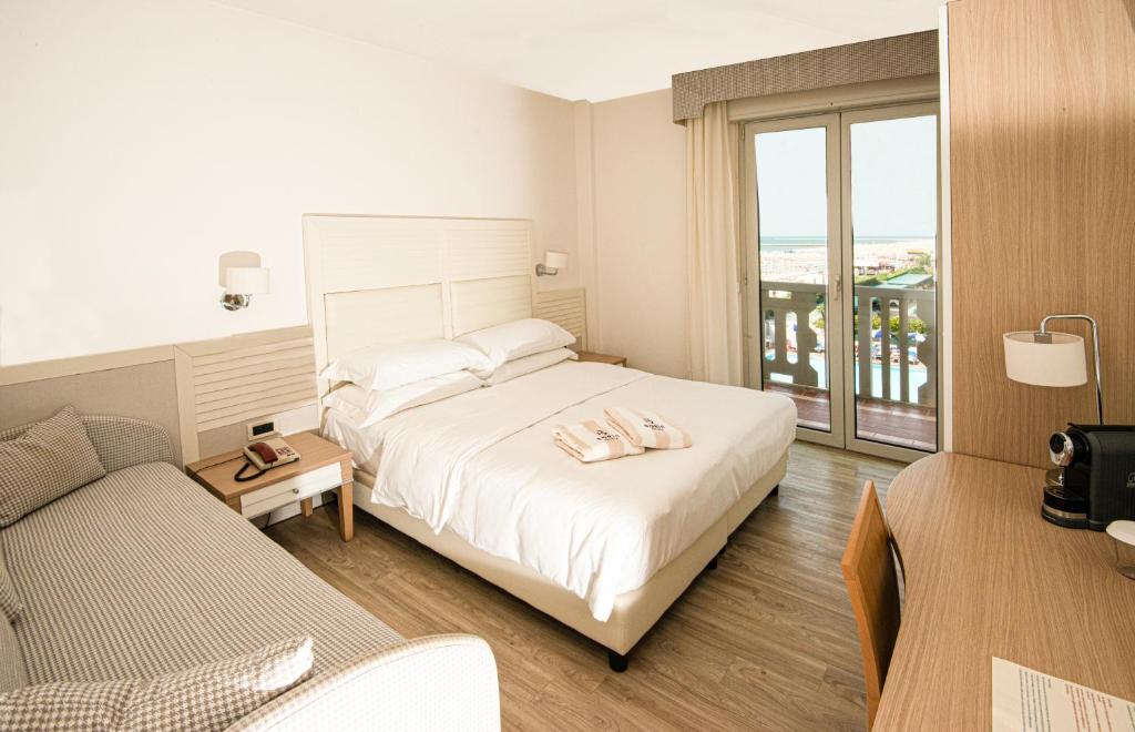 une chambre d'hôtel avec un lit et un balcon dans l'établissement Hotel Savoy, à Caorle 81 autres photos