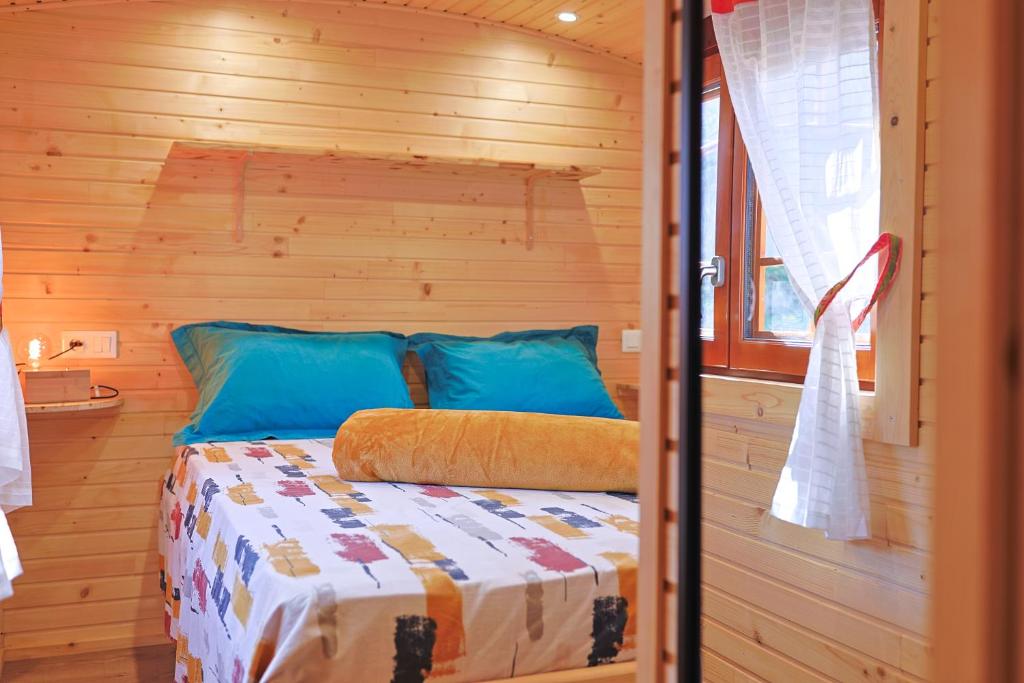 une chambre avec un lit dans une cabane en bois dans l'établissement Roulotte au cœur des vignes, Hyères, à Hyères