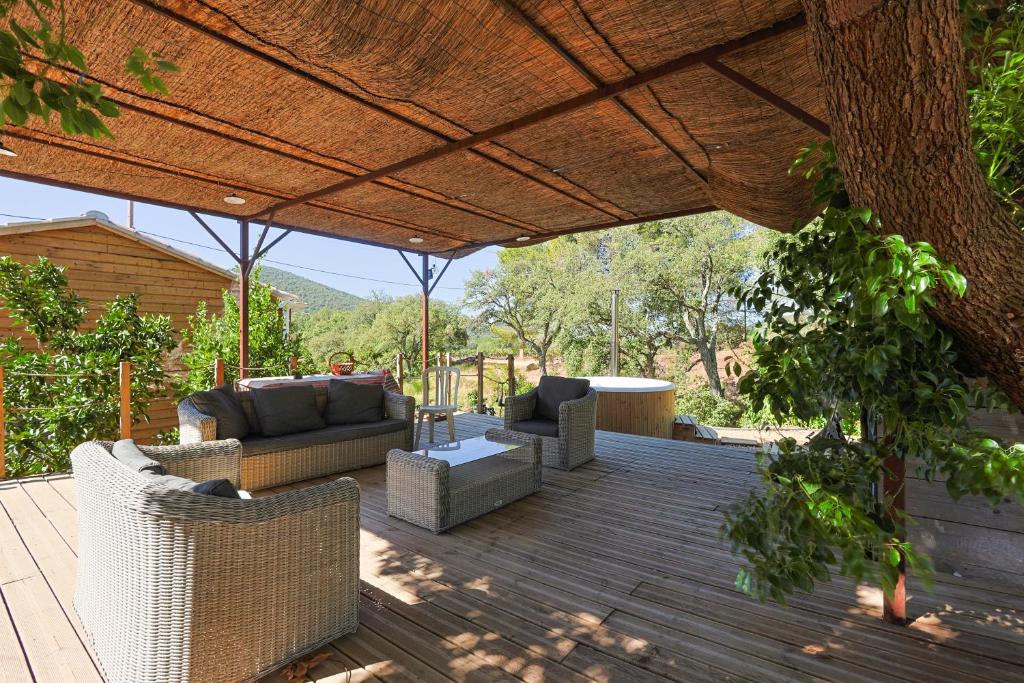 un patio avec des canapés et des chaises sous un toit dans l'établissement Roulotte au cœur des vignes, Hyères, à Hyères